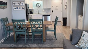 A modern kitchen with white cabinets, a central island, and a ceiling fan.