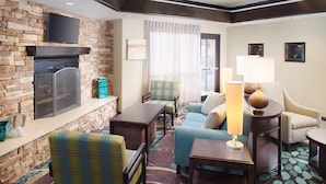 A cozy living room with a fireplace, comfortable seating, and a flat-screen TV mounted above the fireplace. - King Suite in San Angelo | Great for Business Travelers + Parking Available (San Angelo)