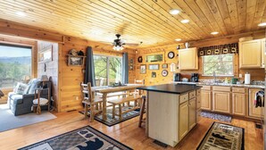 L’intérieur d’un chalet en bois comprend une cuisine, un coin repas et un salon.