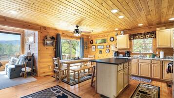 L’intérieur d’un chalet en bois comprend une cuisine, un coin repas et un salon.