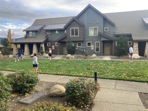 Situated in a well-maintained suburban area, this home features a gabled roof and a mix of siding, surrounded by a manicured lawn and landscaping elements.