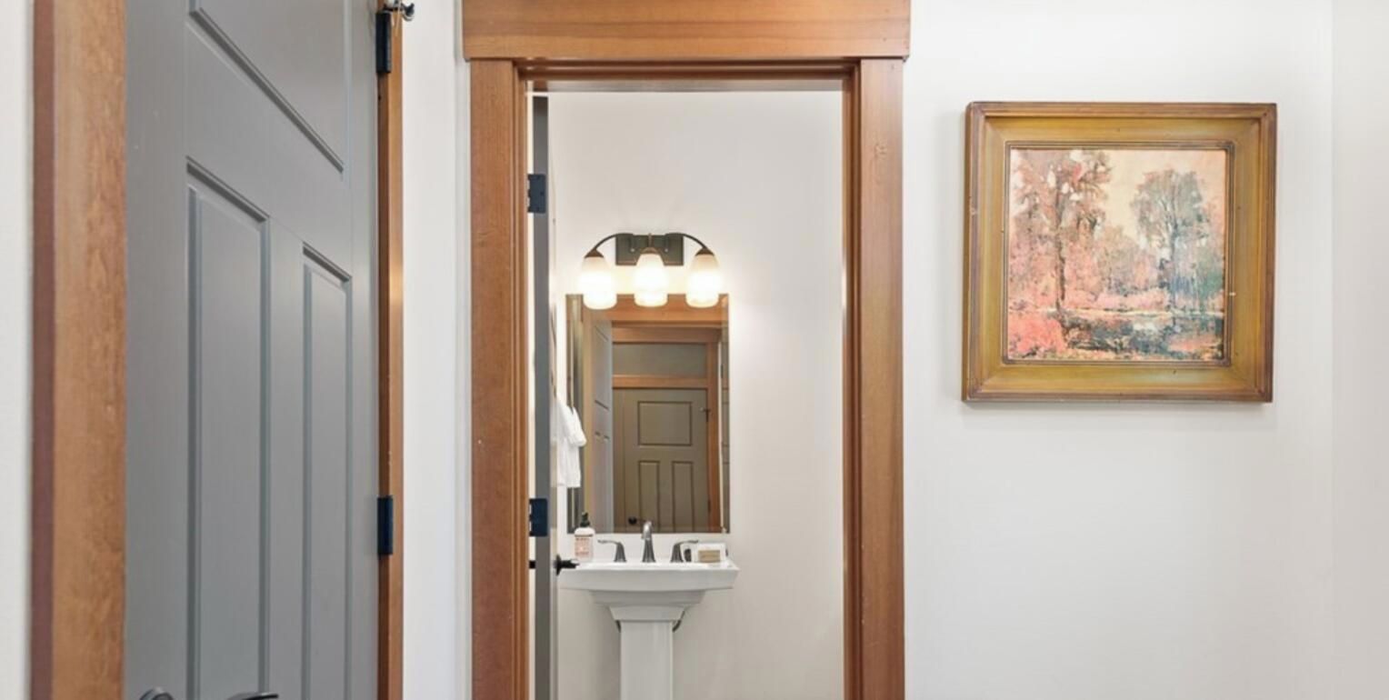 Une salle de bain avec un lavabo, un miroir et un tableau encadré accroché au mur.