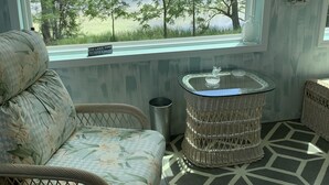 A room with a view of a lake, wicker furniture, a glass table, and a patterned rug. - WELCOME!  Are you looking to get away, to disconnect and relax? Look no further. (Montello)