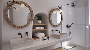 Une salle de bain moderne avec deux lavabos, une douche et trois miroirs encadrés en bois.