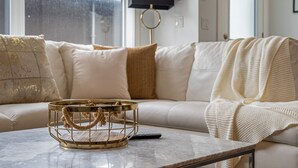 Un salon moderne avec un canapé, une table basse et un téléviseur.