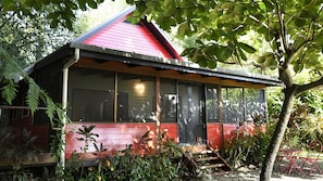 A red-roofed building with large windows and a covered porch.
