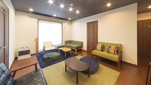 Una sala de estar moderna con un sofá, una mesa de centro, un sillón de saco y una mesita.
