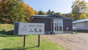 Una casa de huéspedes con un letrero que indica su nombre y un logotipo.