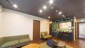 Una sala de estar moderna con un sofá verde, una mesa de centro de madera y un sillón de peluche azul.