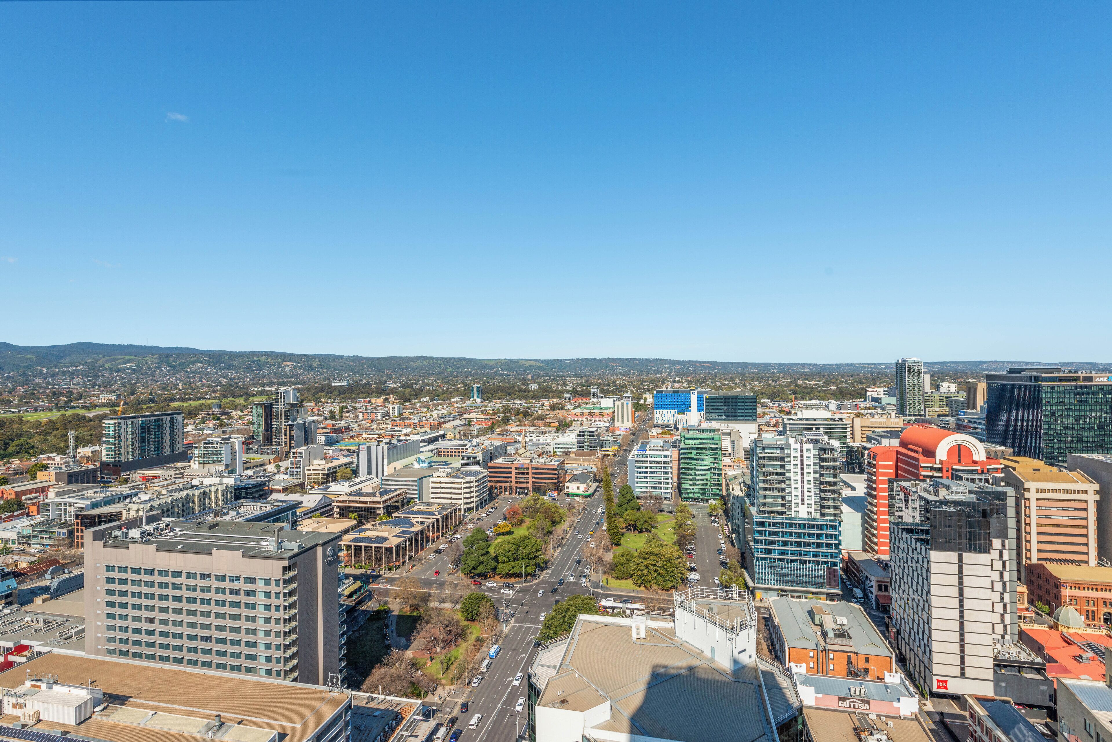 A cityscape with modern buildings, a mix of commercial and residential structures, and a clear sky.