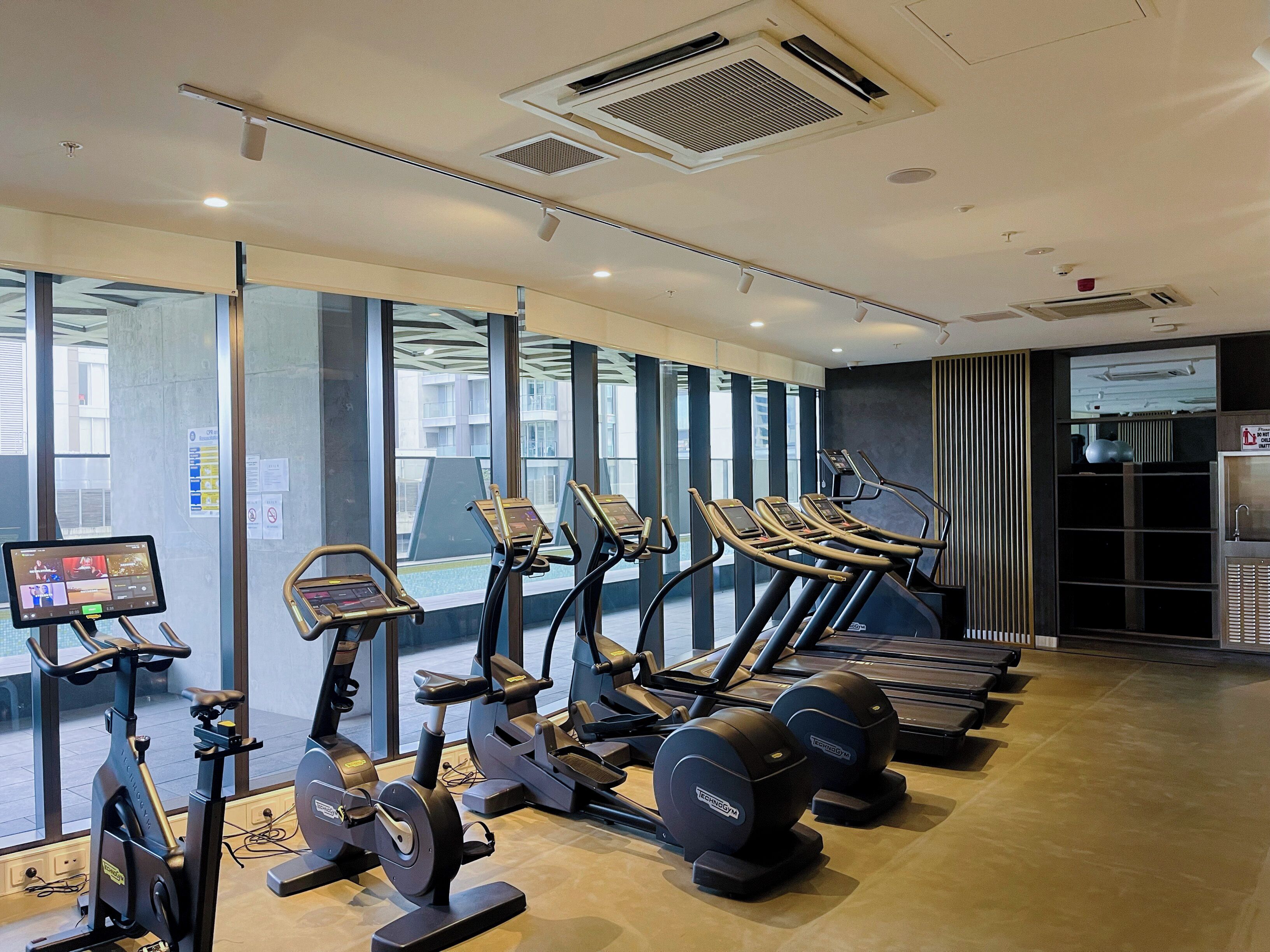 A gym with treadmills, elliptical machines, and weight machines.