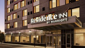 Una entrada moderna de hotel con un gran letrero que dice "Residence Inn by Marriott".