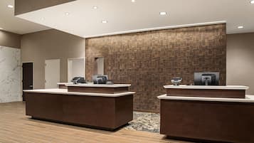 A reception area with two counters, a patterned wall, and a tiled floor.