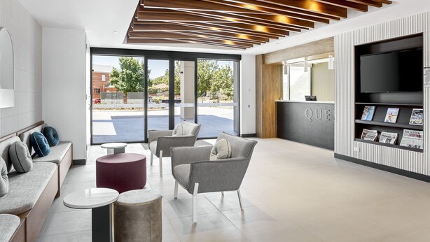A modern lobby with seating areas, a reception desk, and a large TV screen. - Quest Ballarat Station (Soldiers Hill)