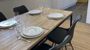 A dining table set with plates, glasses, and cutlery in a modern kitchen with a sloped ceiling and a window. - Newly renovated 80 m2 luxury apartment (Wimereux)