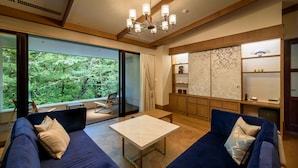 Un salon moderne doté d’une grande fenêtre, d’un ensemble de canapés, d’une table basse et d’un meuble de style japonais traditionnel.
