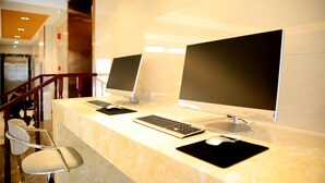 Un comptoir d’accueil équipé de deux ordinateurs de bureau, d’un clavier, d’une souris et d’une chaise.