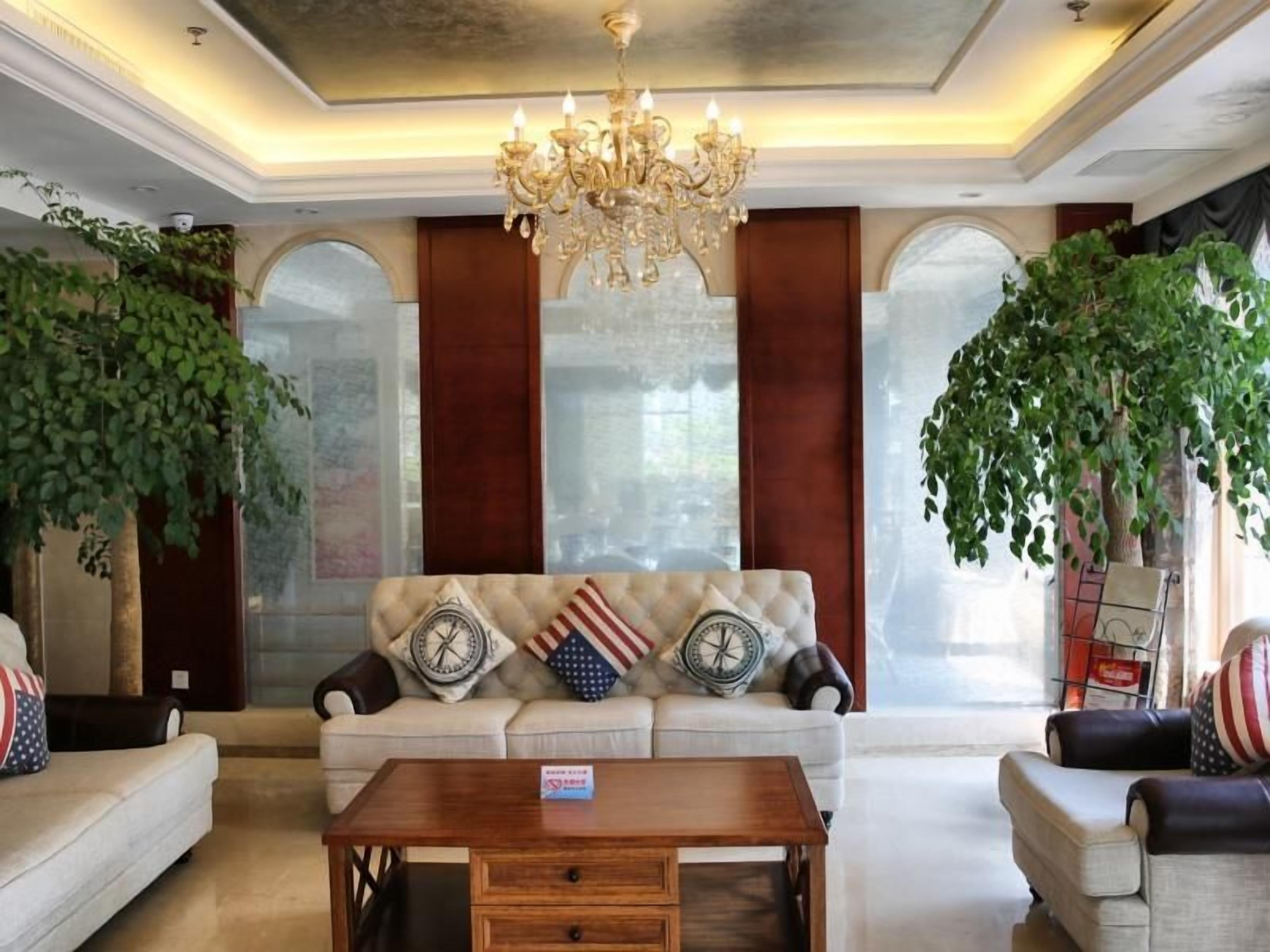 A spacious living room with a sofa set, a wooden coffee table, and a chandelier.