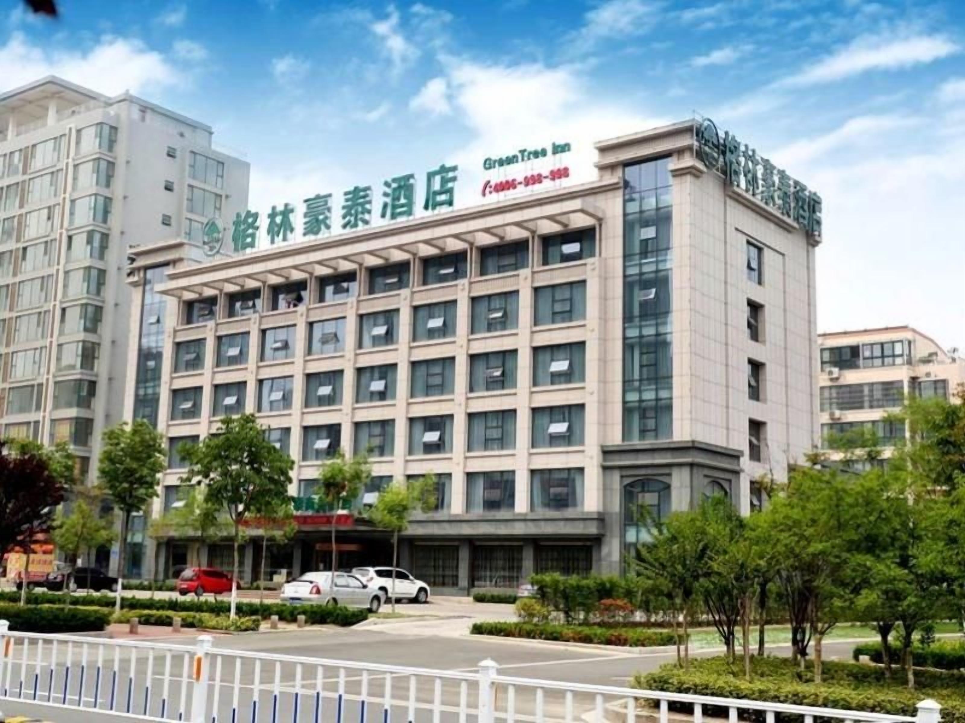 A modern hotel building with multiple floors and a prominent sign for "Green Tree Inn."