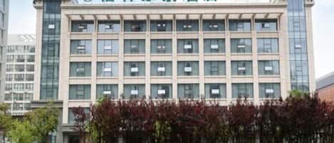 A hotel building with a modern facade, multiple windows, and a sign indicating it is a GreenTree Inn.