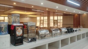 A buffet setup with various food dispensers and a coffee machine.