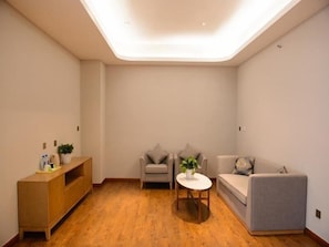 Cozy living space with a sofa, small table, and wooden cabinet.
