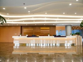 A modern reception area with a curved ceiling, a reception desk, and a large window.