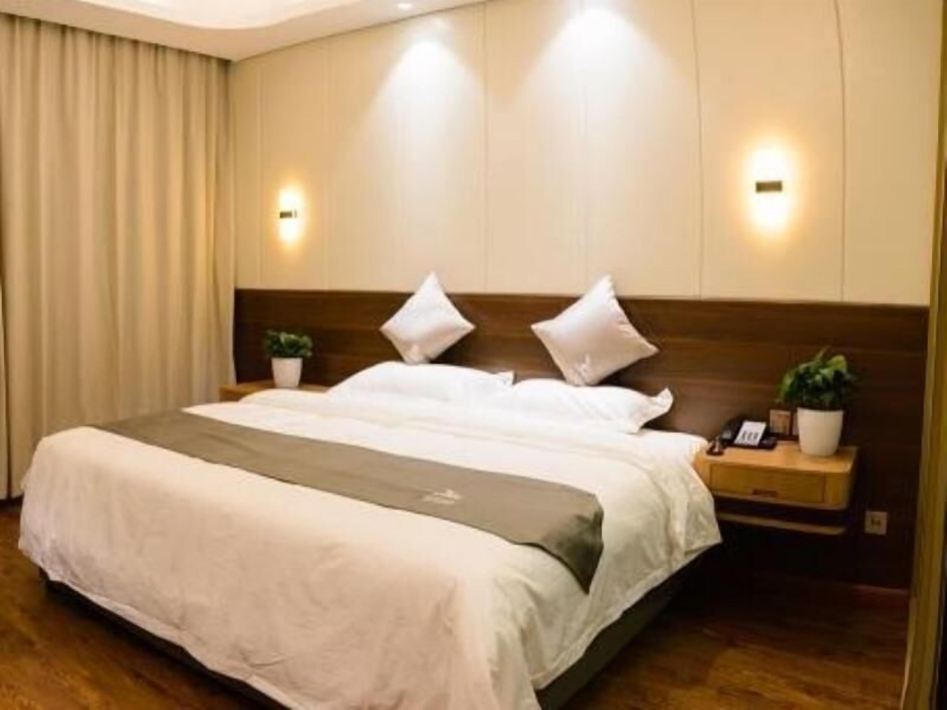 Habitación de hotel con una cama grande, dos mesitas de noche y un cabecero.