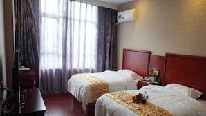 Une chambre d’hôtel avec deux lits, un bureau, une chaise et un appareil de climatisation.