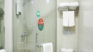 Une salle de bain avec une douche à parois de verre, des toilettes, un lavabo et un porte-serviettes.