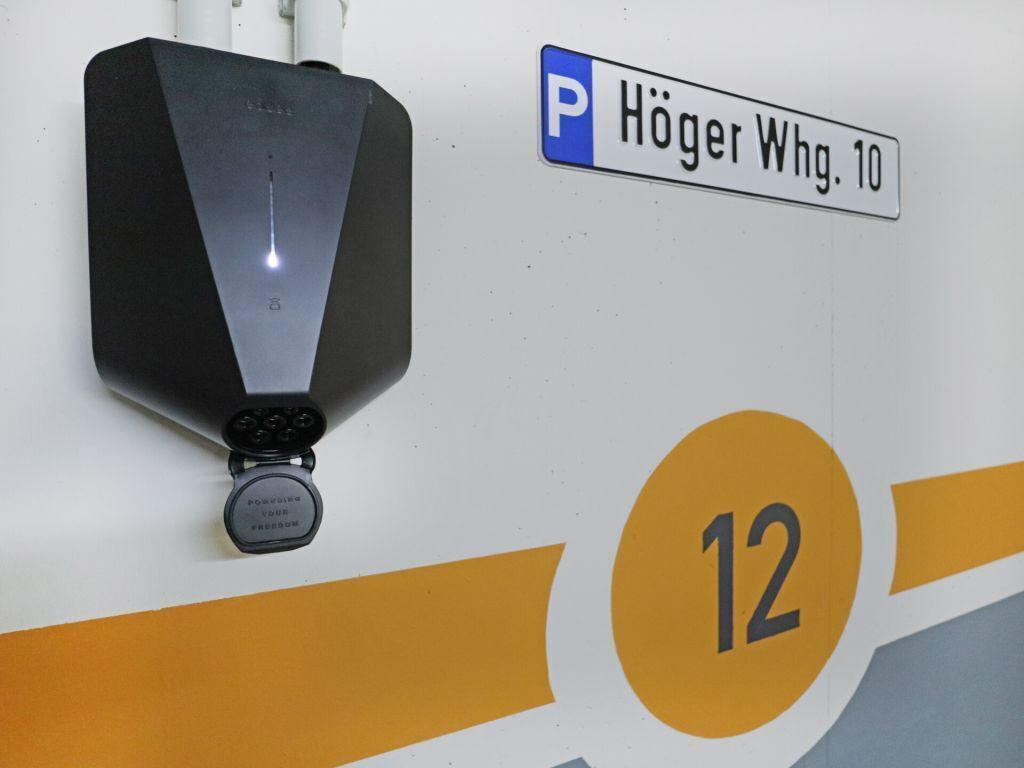 A parking sign for Höger Whg. 10 and a number 12 on a wall.