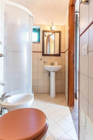 Ein Badezimmer mit Dusche, Waschbecken und Spiegel.