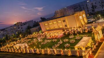 Un patio de hotel con mesas al aire libre y un escenario para eventos.