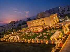 Un patio de hotel con mesas al aire libre y un escenario para eventos.