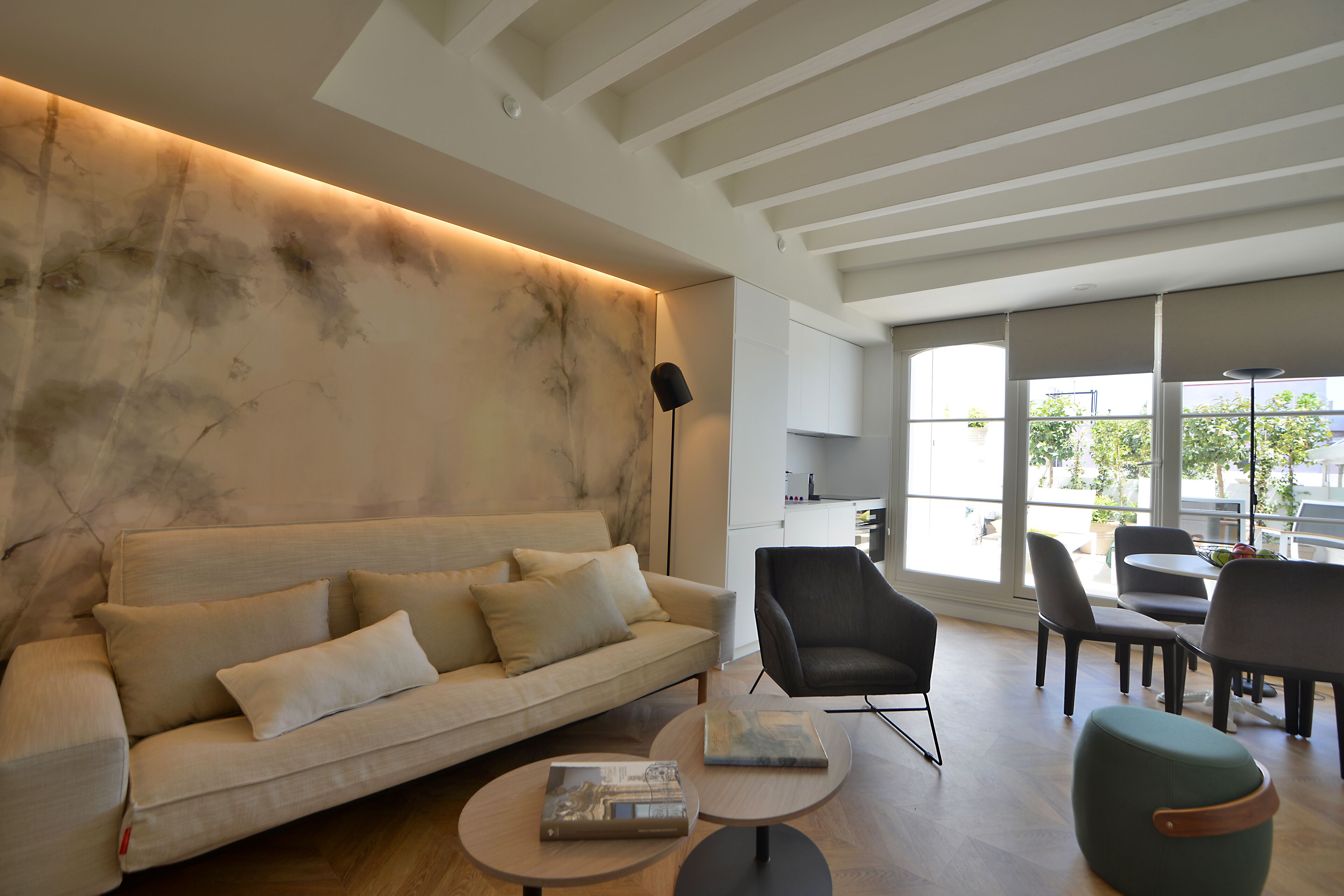 A modern living room with a sofa, armchairs, and a coffee table.