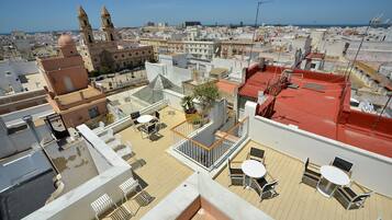 A rooftop terrace with outdoor seating and a view of the cityscape.