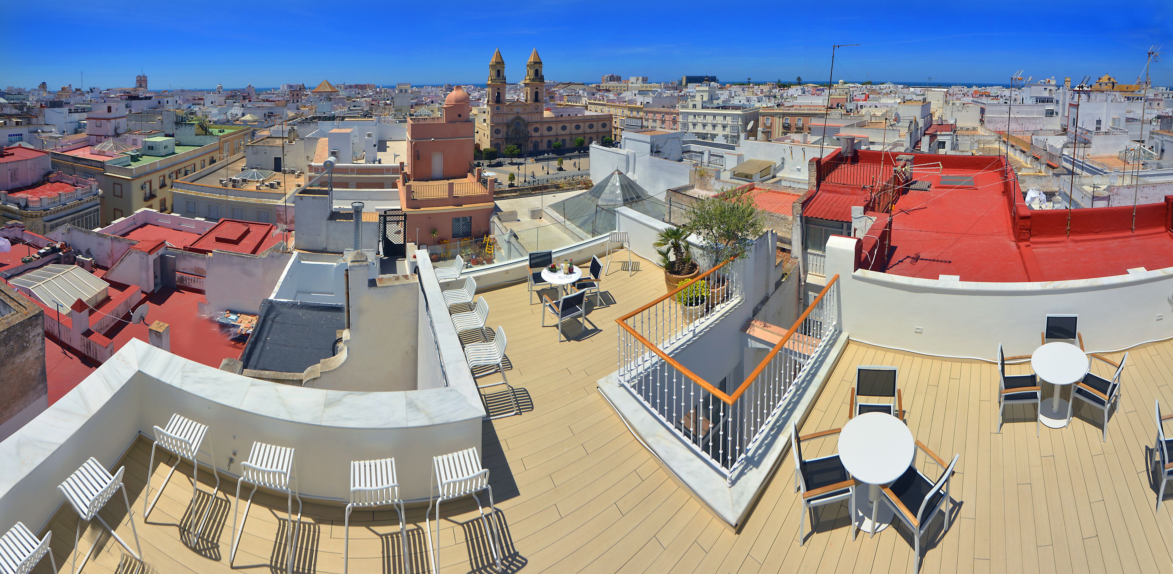 Terraza en la azotea con mobiliario y vista panorámica de la ciudad.
