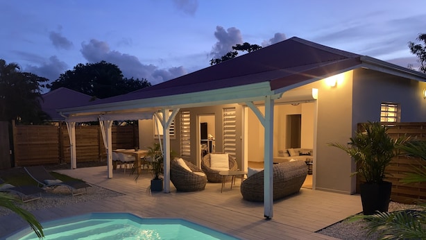 A covered outdoor area with a swimming pool, lounge chairs, and a dining table. - Villa Samathan 3 bedrooms private pool 5mn from the beach (Saint-François)