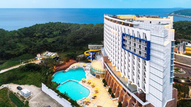Un hotel con piscina, tobogán de agua y vistas al mar.