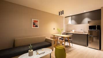 Uma sala de estar moderna com sofá, mesa de centro e área de jantar com cadeiras e mesa.
