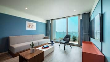 A modern living room with a sofa, a coffee table, a chair, and a TV mounted on the wall.