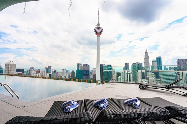 Una piscina al aire libre, sillones reclinables de piscina
