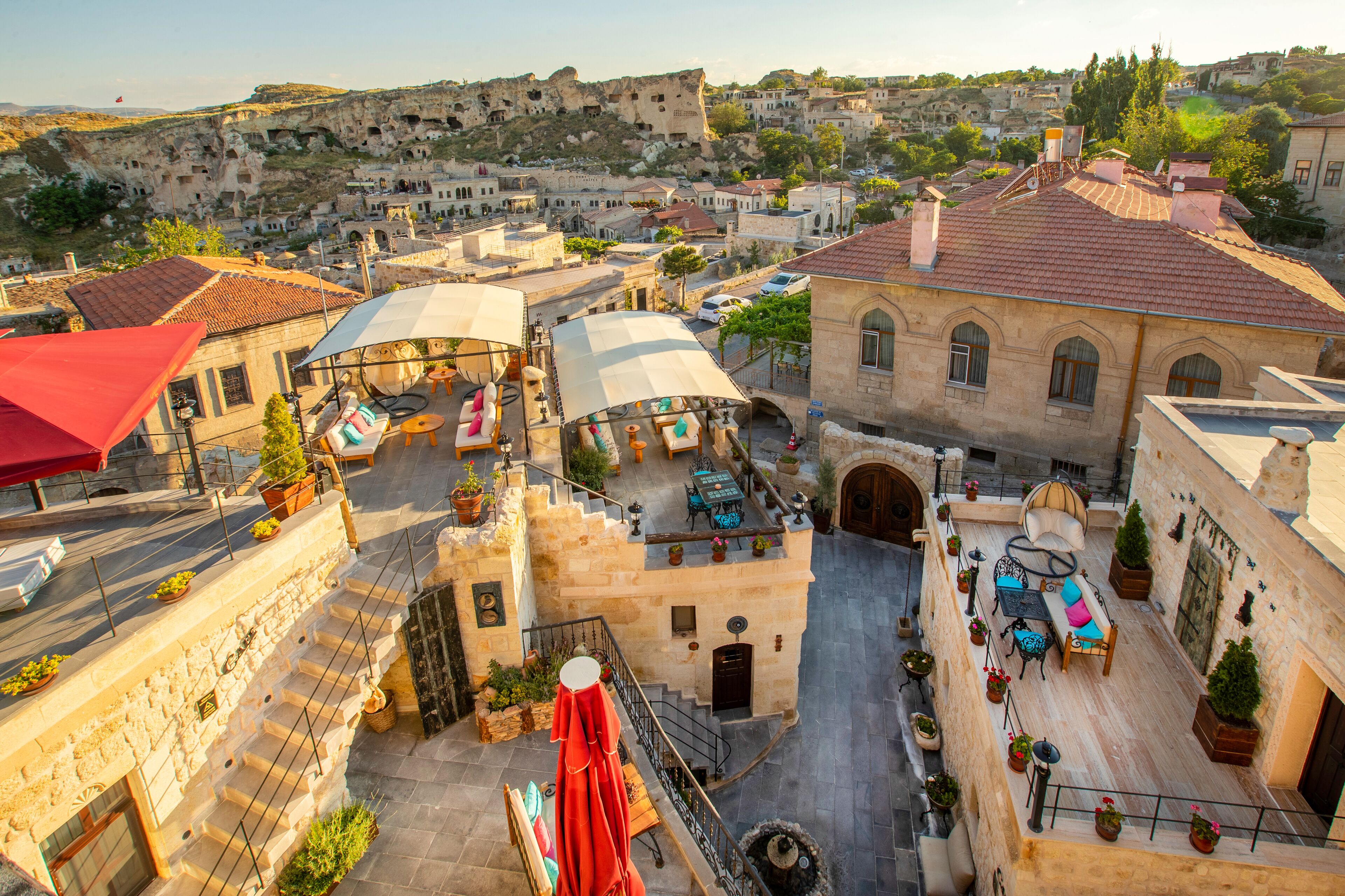 A rooftop terrace with outdoor seating, a stone staircase, and a view of the surrounding town.