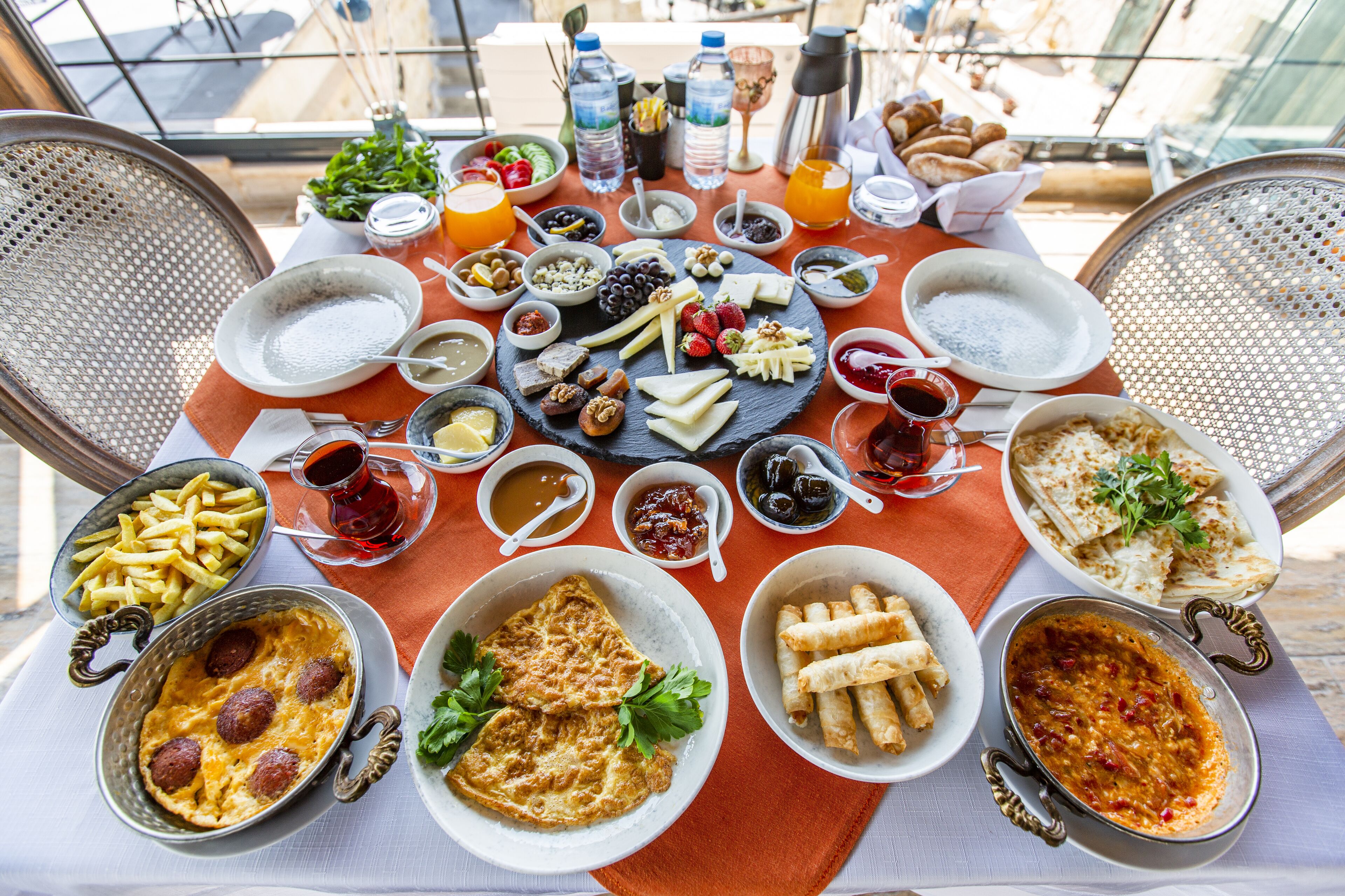 A table set with a variety of breakfast items including pastries, fruits, cheeses, and beverages.