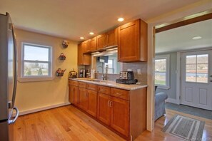 Enjoy meals in this well-equipped kitchen with a refrigerator, dining area, and natural light.