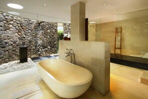 Relax in a serene bathroom with a bathtub and glass shower enclosure.
