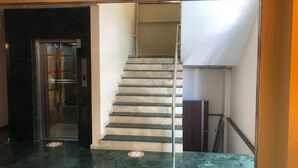 A staircase with a handrail and a door leading to an elevator. - Otel Bostanci (Izmit)