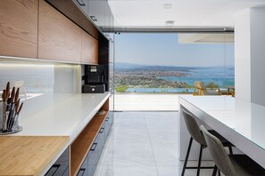 Enjoy ocean and city views from this kitchen with a large island and ample counter space.