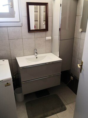 Een bad/douchecombinatie, handdoeken