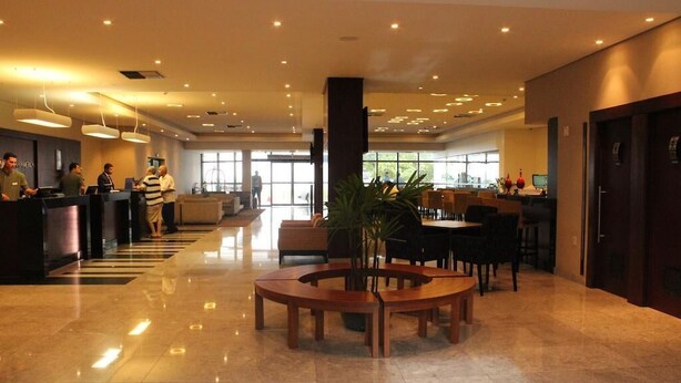 A spacious lobby with a reception desk, seating area, and large windows. - Betel Beach Flat (Recife)